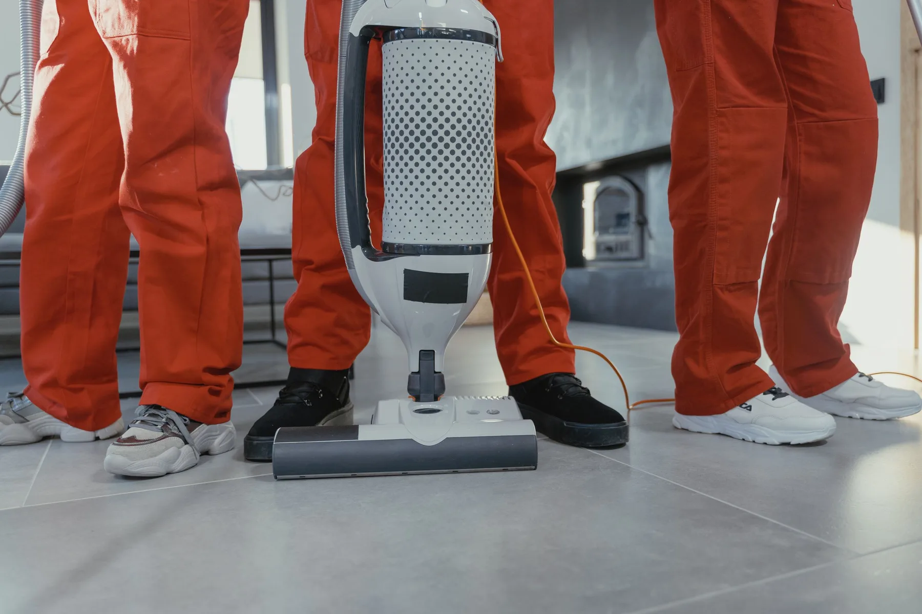Twee schoonmakers met een bouwstofzuiger op een kale vloer